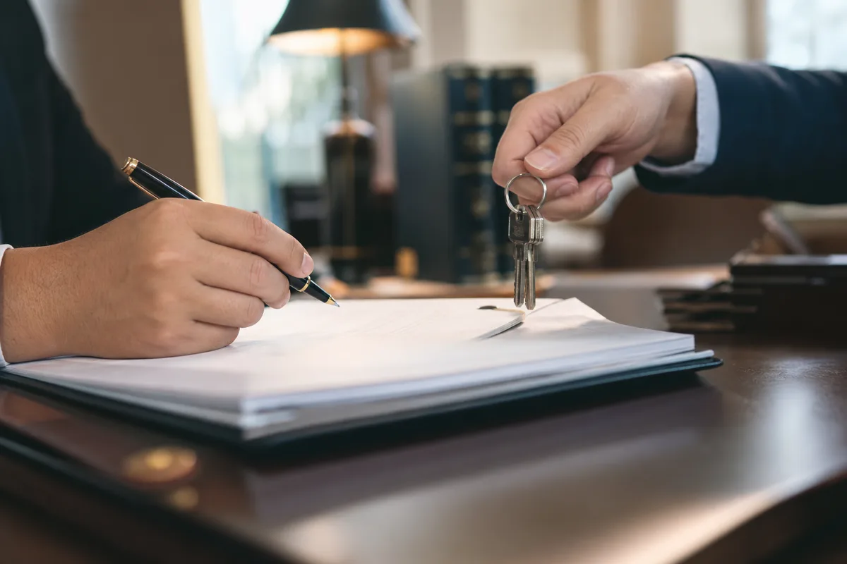Signature du dossier de vente chez le notaire avec remise des clés de la maison